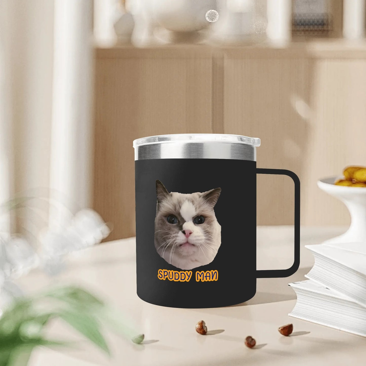 Black mug with a cat design and 'Spuddy Man' text on a blurred background