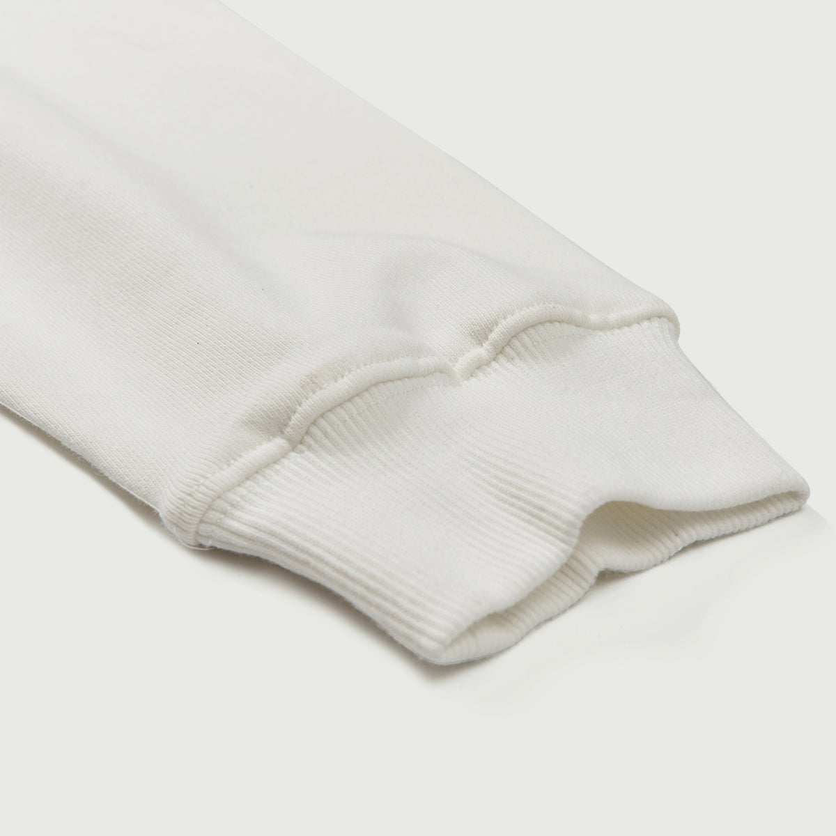 Close-up of a light gray sweatshirt sleeve on a white background