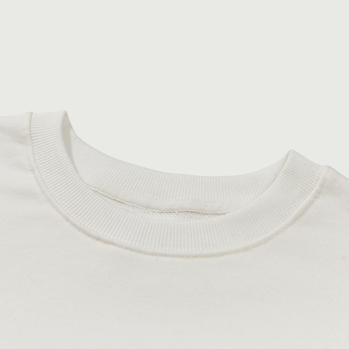 Close-up of a white sweater collar on a light gray background